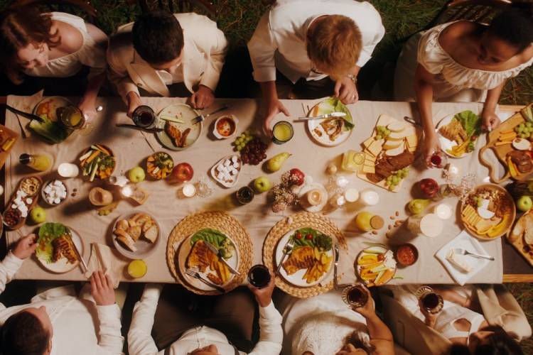 aerial view of a dinner party with table filled with plates and beautiful food