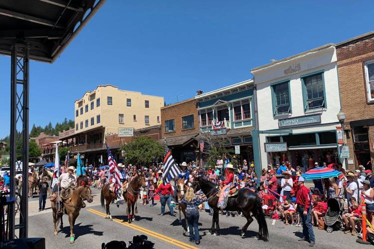 Crowd of people gathered on the street to watch horses in a parade