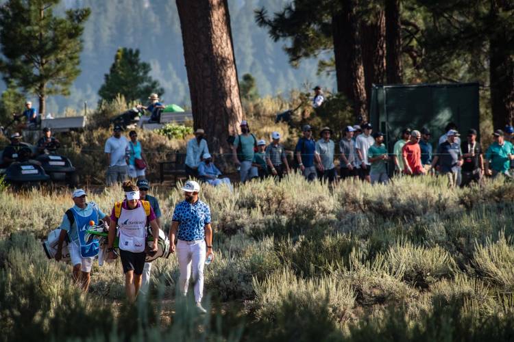 Golfers walking through the bushes to get to the next hole