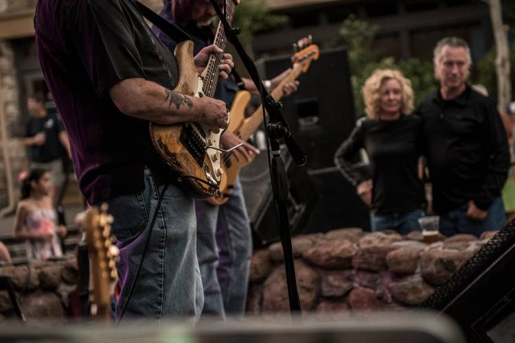 Close up of men playing the guitar on stage.