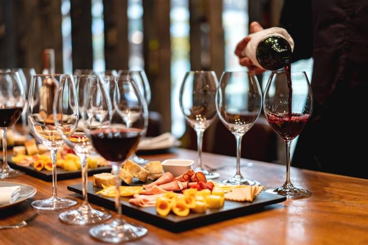 person pouring glasses of wine at a wine festival