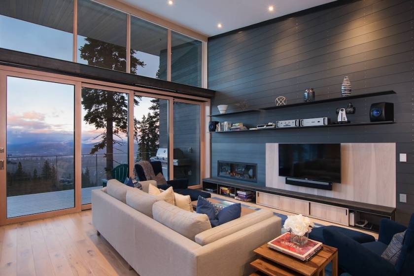 Modern vacation rental interior with large picture windows and scenic mountain views