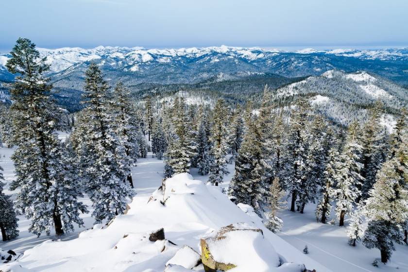 View of a snow-covered slope and surrounding mountains from the top of Northstar Resort near Lake Tahoe, California